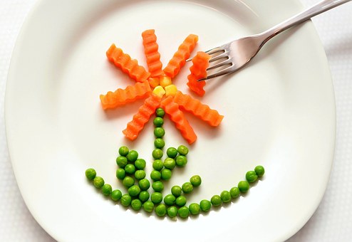 dibujo de una flor en un plato hecho con zanahoria y guisantes dibujo de una flor en un plato hecho con zanahoria y guisantes