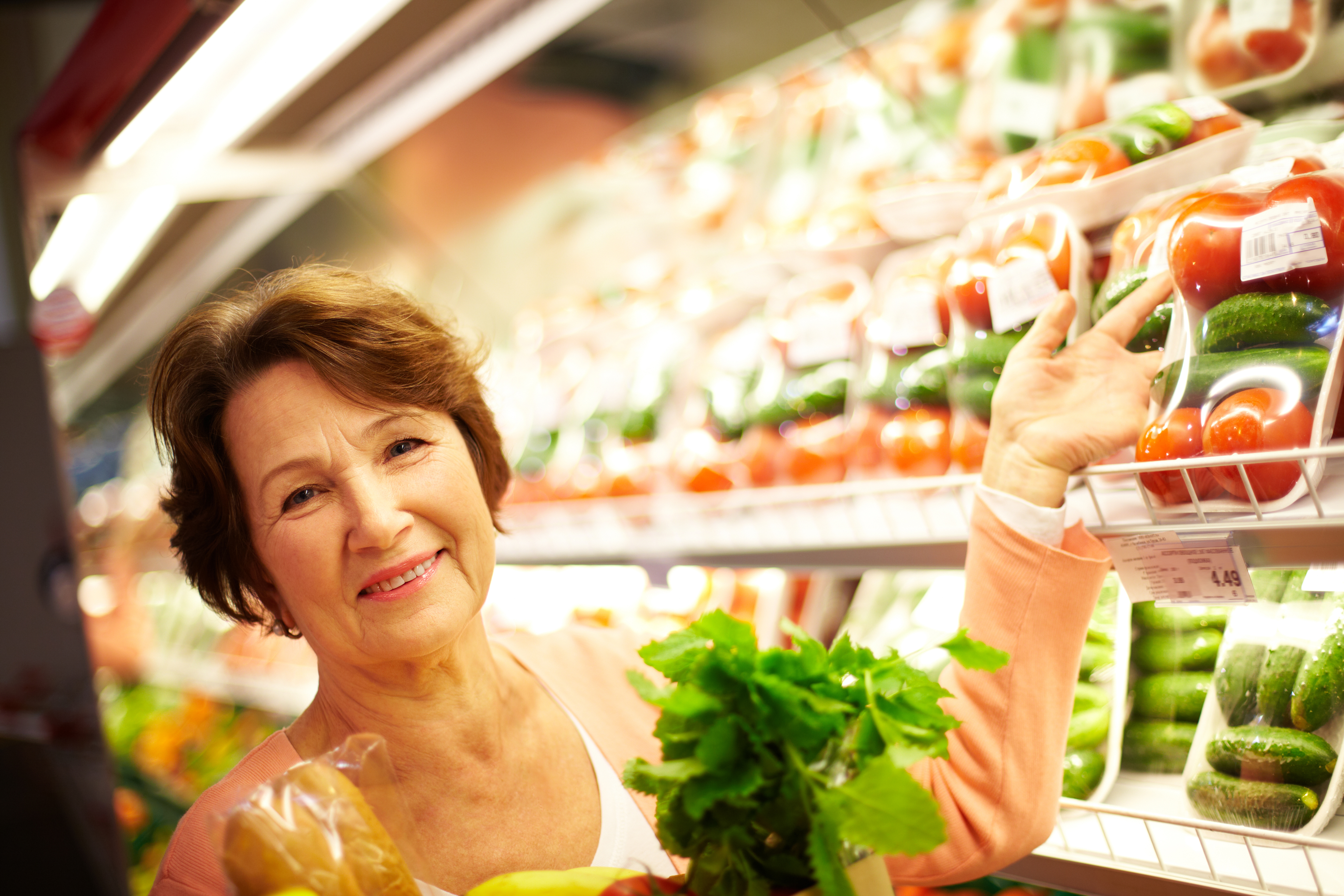mujer madura comprando en un mercado de verduras y fruta