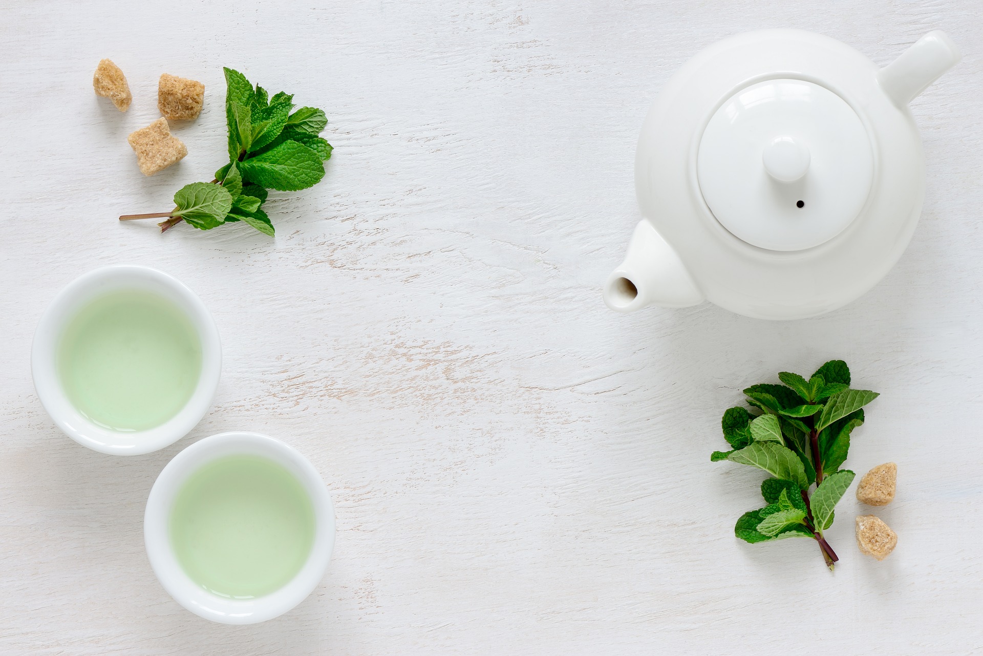 mesa con tetera y dos tazas de té verde